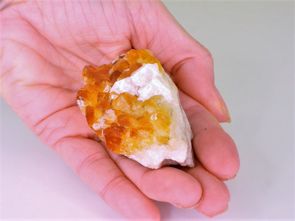 Beautiful Citrine cluster with inclusions in someone's hand. Top view