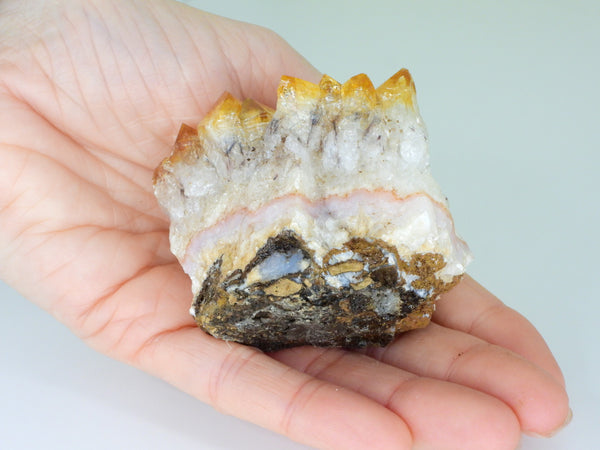 Beautiful Citrine cluster with inclusions in someone's hand. Side bottom view