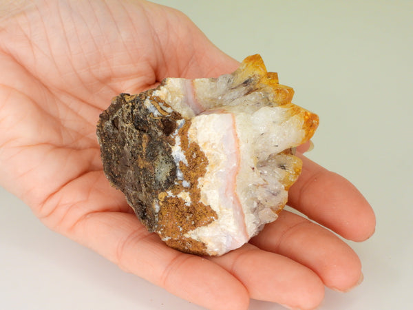 Beautiful Citrine cluster with inclusions in someone's hand. Bottom view