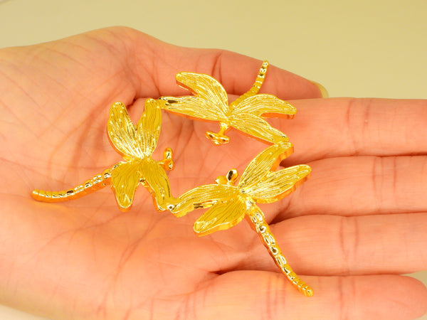Gold small dragonfly sphere stand in someone's hand. Top view