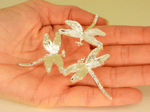 Silver small dragonfly sphere stand in someone's hand. Top view