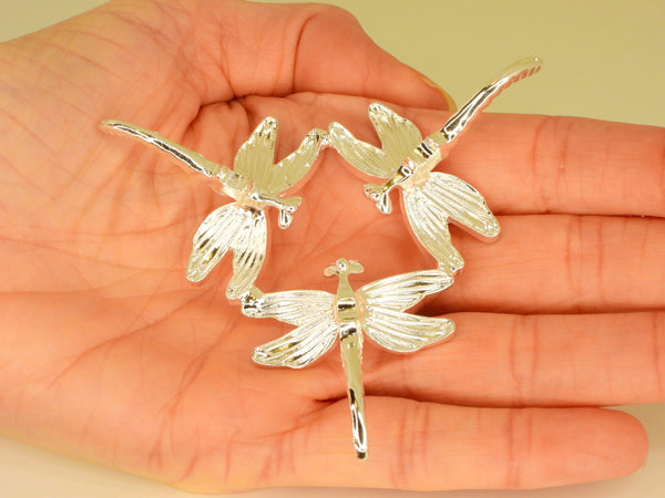 Silver small dragonfly sphere stand in someone's hand. Bottom view