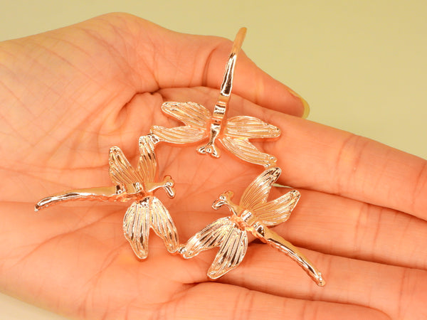 Rose Gold small dragonfly sphere stand in someone's hand. Bottom view