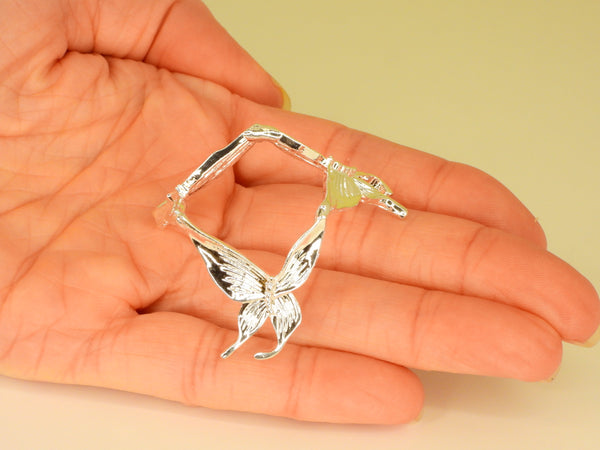 Silver small butterfly sphere stand in someone's hand. Top view
