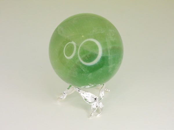 Silver small butterfly sphere stand holding a fluorite sphere. Front view