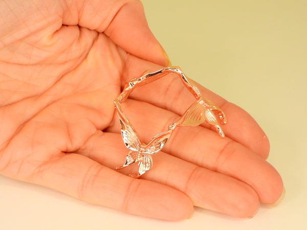 Rose gold small butterfly sphere stand in someone's hand. Top view