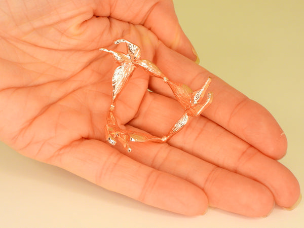 Rose gold small butterfly sphere stand in someone's hand. Bottom view