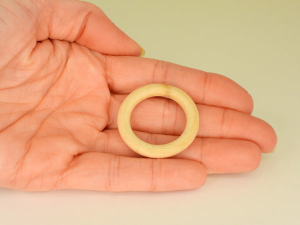 Small wooden ring sphere stand in someone's hand. Top view