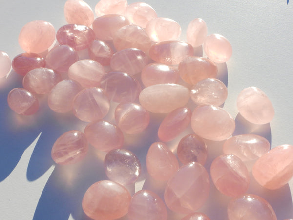 Lots of high quality Rose Quartz pumbles sparkling in the sunshine. Close up