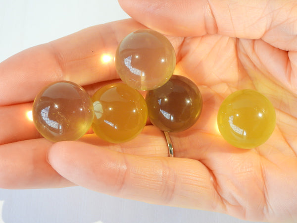 Multiple Star Citrine spheres in someone's hand, 9g size