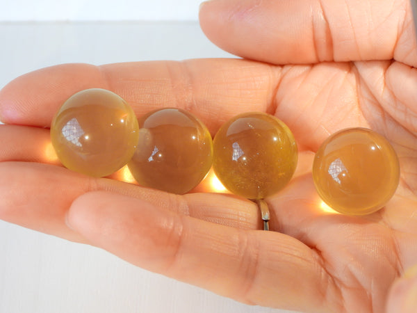 4 Star Citrine spheres in someone's hand, 10g size