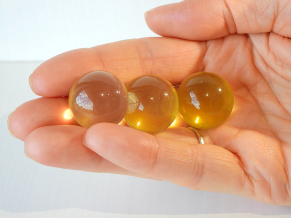 3 Star Citrine spheres in someone's hand, 12g size